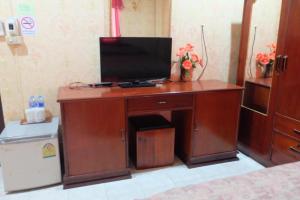 un escritorio de madera con TV encima en Thaveesinh Hotel, en Ban Houayxay