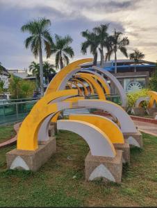 a row of curved benches in a park with palm trees at Lumuda Hotel in Lumut