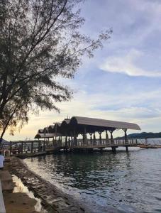 a dock with a pavilion on the water at Lumuda Hotel in Lumut