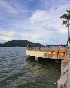 a pier on a body of water with people on it at Lumuda Hotel in Lumut