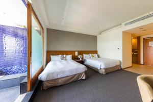 ein Hotelzimmer mit 2 Betten und einem Fenster in der Unterkunft South Garden Hotels And Resorts in Zhongli