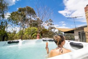 Una donna in piscina che beve di 4 Bedroom fun house - spa, sauna, fire pits & more a Healesville