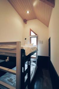 ニセコ町にあるGoodfellas Onsen Houseの窓付きの客室で、二段ベッド2台が備わります。
