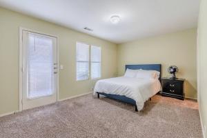 a bedroom with a bed with a blue headboard and two windows at Cozy 2BD/3BA with Balcony/Patio/Free Parking/Fast Wifi! 5min to Downtown Plano! in Plano