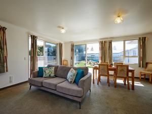a living room with a couch and a table at Torquay Central - Kaikoura Holiday Home in Kaikoura