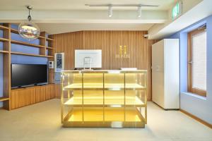 a lobby with a gold display case and a television at H HOSTEL Itaewon in Seoul