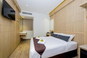 a bedroom with a large bed with a tv on the wall at Hotel 81 Premier Star in Singapore
