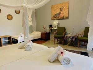 1 dormitorio con 1 cama con toallas en Ombe Guestfarm & Safari, en Hochfeld