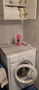 una lavadora con un contenedor rosa encima en Riza Falasarna Apartments 50m2, en Falasarna