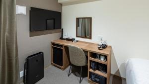 福岡市にあるホテルリファレンス天神Ⅲのデスク、鏡、ベッドが備わる客室です。