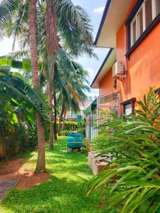 a yard with palm trees next to a house at The Park Pool Villa Pattaya in Pattaya Central