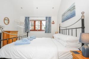 a bedroom with a bed with towels on it at Pol Glas Cabin in Helston