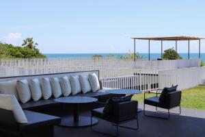 a patio with a couch and two tables and chairs at Sundance Dayclub Hua Hin in Hua Hin