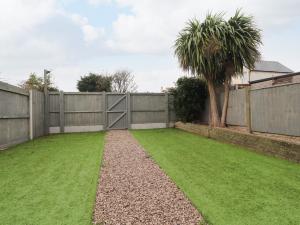 a garden with a fence and a palm tree at 37 Nutter Road in Cleveleys