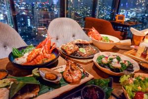 une table contenant différents types de denrées alimentaires dans l'établissement The Continent Hotel Sukhumvit - Asok BTS Bangkok, à Bangkok