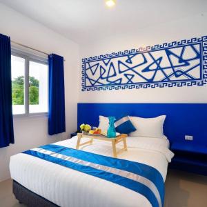Ruhe Suites Coron في كورون: غرفة نوم زرقاء وبيضاء بسرير كبير