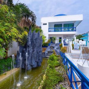 a house with a waterfall in front of a house at Ruhe Suites Coron in Coron