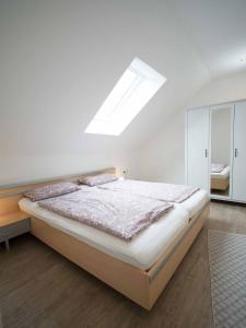 - une chambre avec un grand lit et une lucarne dans l'établissement Ferienhaus Müller, à Merzig