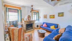 a living room with a blue couch and a fireplace at El Garrotal - El Pan El Bosque by Ruralidays in El Bosque