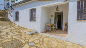 a white house with a door leading to a patio at El Garrotal - El Pan El Bosque by Ruralidays in El Bosque