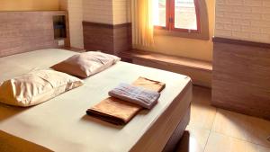 twee bedden in een kamer met twee handdoeken erop bij Hotel Syariah Larismanis in Semarang