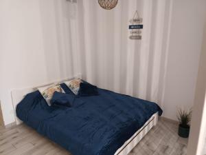 łóżko z niebieską kołdrą w sypialni w obiekcie Łebskie Zacisze - apartamenty Łebska Ostoja- Piaskowa w mieście Żarnowska