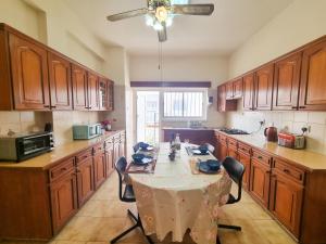 una cucina con tavolo, sedie e ventilatore a soffitto di Luxury City Rooms a Larnaka