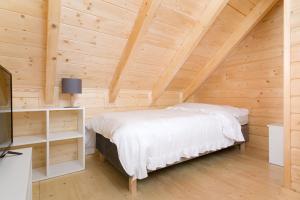 ein Schlafzimmer mit einem Bett in einer Holzdecke in der Unterkunft ,,Morski Zakątek'' Domki całoroczne in Ustronie Morskie