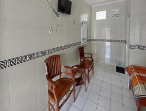a room with three chairs and a table and a tv at RedDoorz Syariah @ Hotel Sidomulyo Pacitan in Pacitan +8 photos