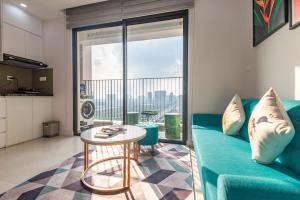een woonkamer met een blauwe bank en een tafel bij Vinhomes Dcapital luxury appartment in Hanoi