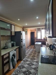 een keuken met een koelkast en een vaatwasser bij 3-х комнатная аппартамент in Tasjkent