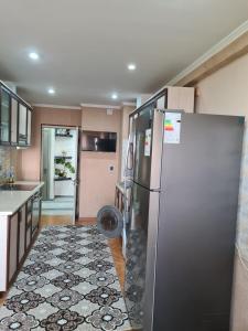 uma cozinha com um frigorífico de aço inoxidável e piso em azulejo em 3-х комнатная аппартамент em Tashkent