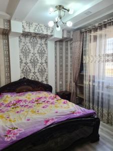 een slaapkamer met een bed met een paars dekbed bij 3-х комнатная аппартамент in Tasjkent