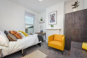 a bedroom with a bed and a yellow chair at Private Room in a Shared Accommodation in Norwood