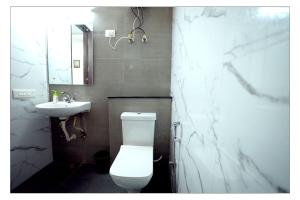 uma casa de banho com um WC branco e um lavatório. em Gupta Residency em Noida