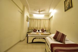 a room with two beds and a window at Hotel Kalpana Palace, Mumbai in Mumbai