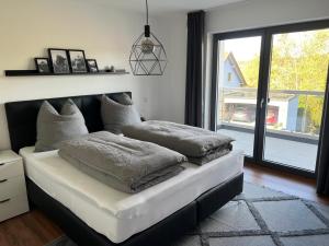 a bed with pillows on it in a room with a window at Ferienwohnungen am Jura in Weißenburg in Bayern