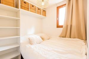 Ce lit se trouve dans un dortoir doté d'étagères et d'une fenêtre. dans l'établissement Appartement Les Arcs Ski aux pieds à Vallandry, à Landry