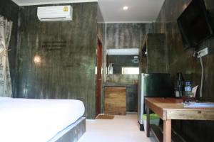 een slaapkamer met een bed, een bureau en een tafel bij Le Pes Villas in Khanom