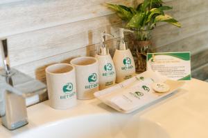 a bathroom counter with three toiletries on a sink at Biet Dien Hotel in Buon Ma Thuot
