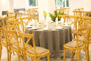 uma mesa com uma toalha de mesa cinzenta e cadeiras em Biet Dien Hotel em Buon Ma Thuot