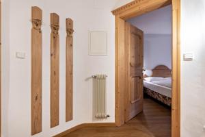 a bedroom with a door leading to a bed at Cesa Valeria App Monika in Ortisei