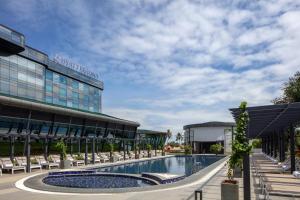 a hotel with a swimming pool in front of a building at Hyatt Regency Trivandrum in Trivandrum