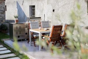 stół i krzesła siedzące obok kuchenki w obiekcie Apartment Na Krki w mieście Kostanjevica na Krki