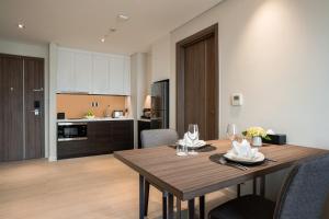 cocina y comedor con mesa de madera y sillas en Oakwood Residence Hanoi, en Hanói