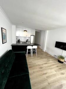ein Wohnzimmer mit einem Sofa und einer Küche in der Unterkunft Centrally located modern 2-bedroom home & parking in Kapstadt