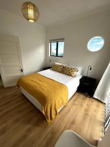 Un dormitorio con una cama con una manta amarilla. en Centrally located modern 2-bedroom home & parking, en Ciudad del Cabo