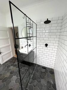 y baño con ducha acristalada y lavamanos. en Centrally located modern 2-bedroom home & parking, en Ciudad del Cabo