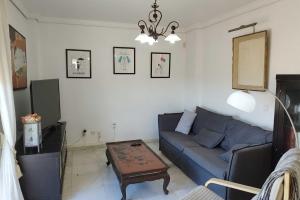 salon z niebieską kanapą i stołem w obiekcie Jabeque w mieście Estepona