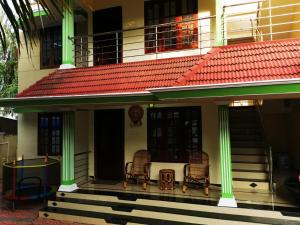 duas cadeiras no alpendre de um edifício em J2 Home Stay - Luxury Homes with Caravan Services em Trivandrum
